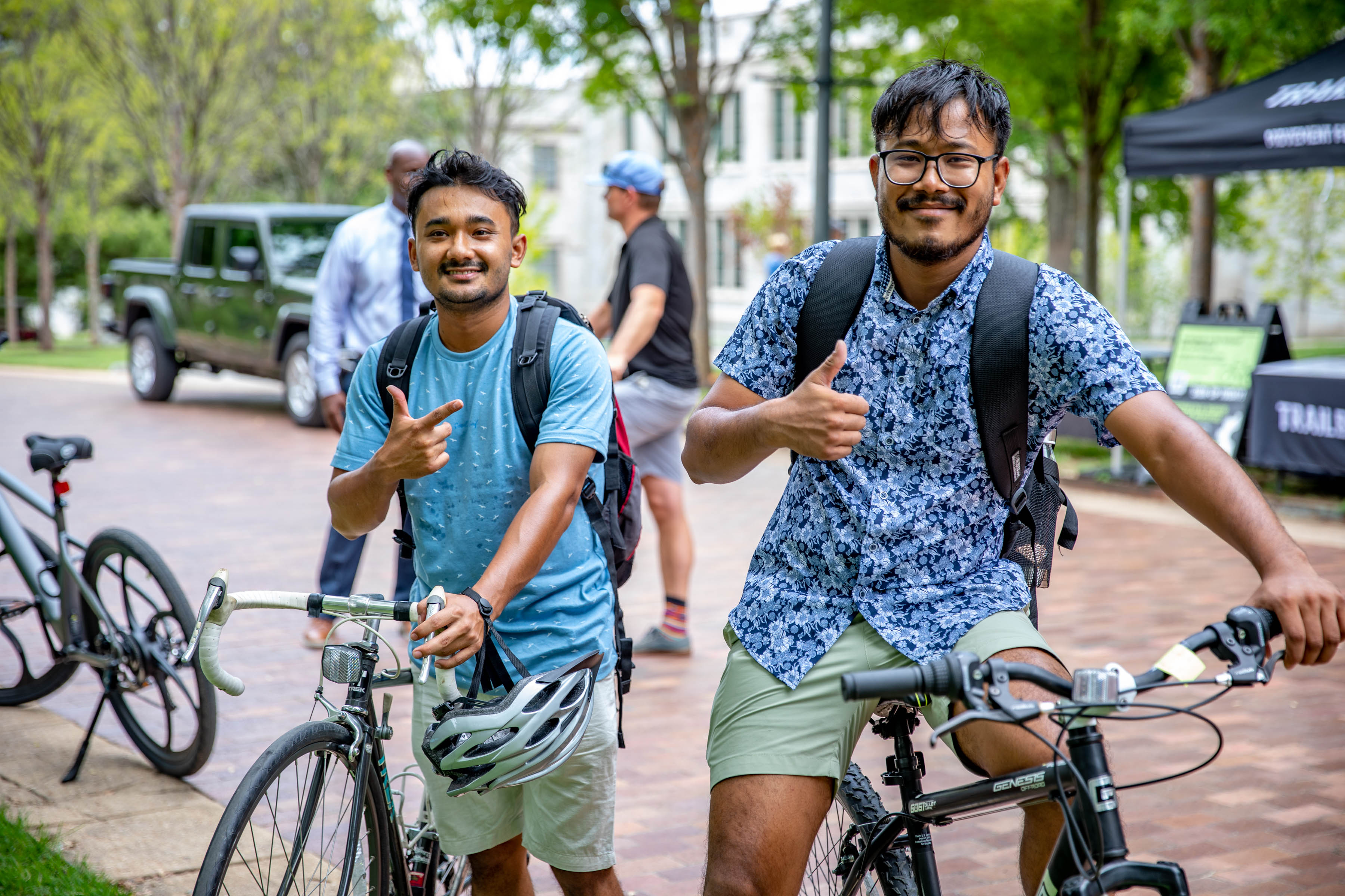 Two students smiling with their bikes at a bicylce event on campus